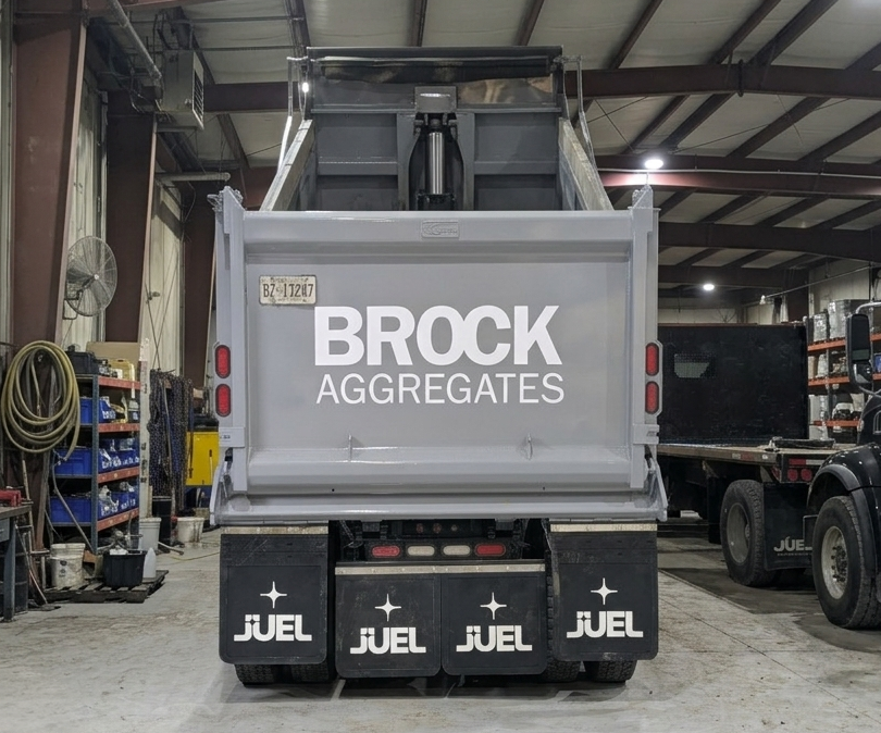 Delivery Services Page: the rear of a Brock Aggregates truck with a prominent logo displayed inside of a warehouse